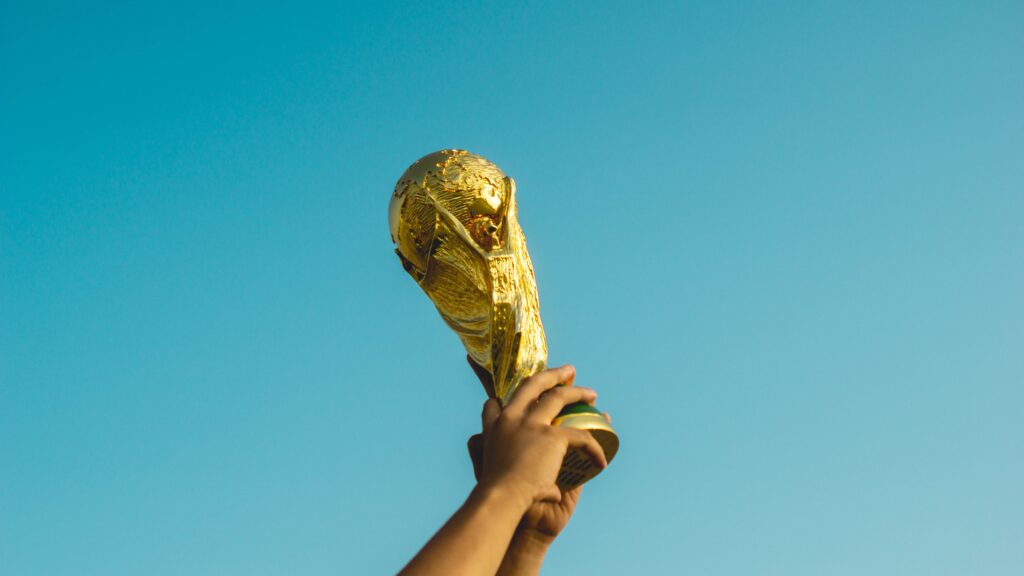 Hands holding up a golden trophy to the sky.