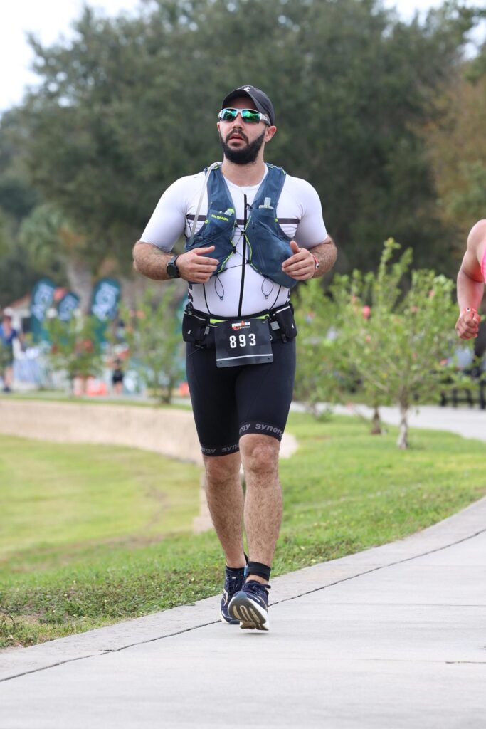 Me running on a concrete path during my Ironman 70.3.